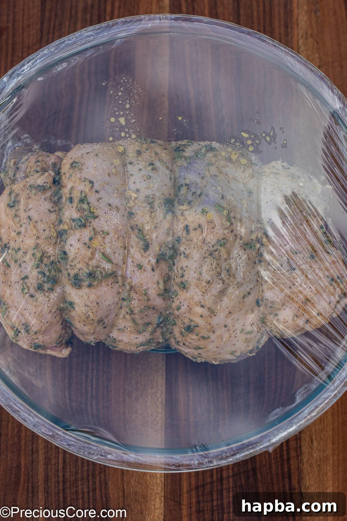 Succulent Boneless Roast Lamb 15 The lamb marinating in a mixing bowl, covered with plastic wrap.