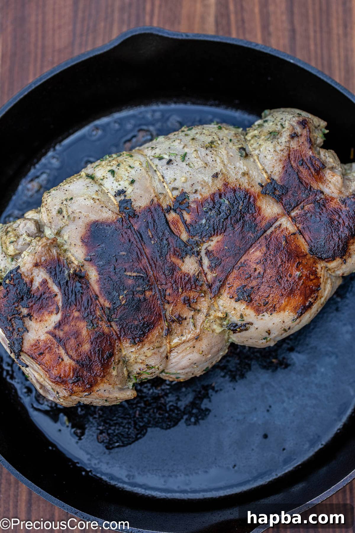 Succulent Boneless Roast Lamb 16 Seared lamb resting in a cast iron skillet on the stovetop.
