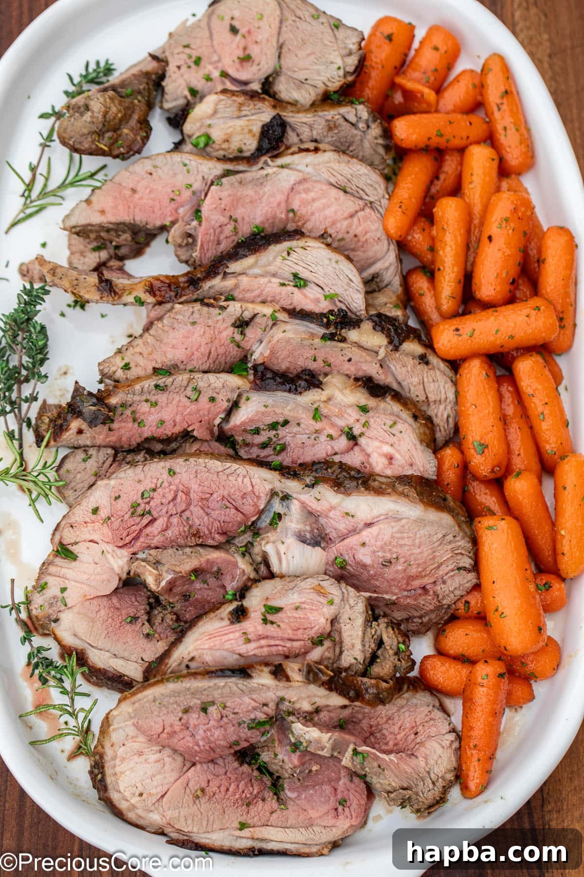 Succulent Boneless Roast Lamb 19 Beautifully sliced roasted lamb and glazed carrots on a white serving tray.