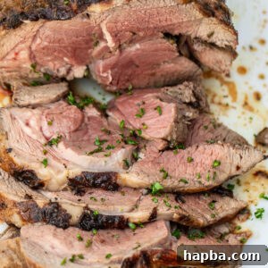 A sliced roasted boneless leg of lamb, showcasing its tender texture.