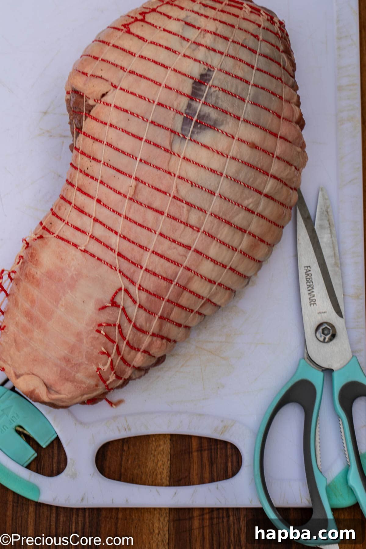 Succulent Boneless Roast Lamb 7 Carefully cutting off the outer covering from the lamb roast package.