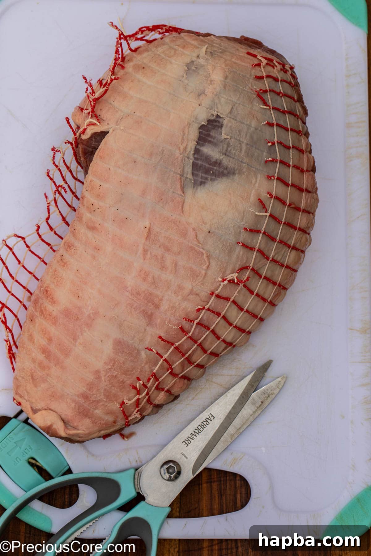 Succulent Boneless Roast Lamb 8 Removing the netting from a boneless leg of lamb before preparation.