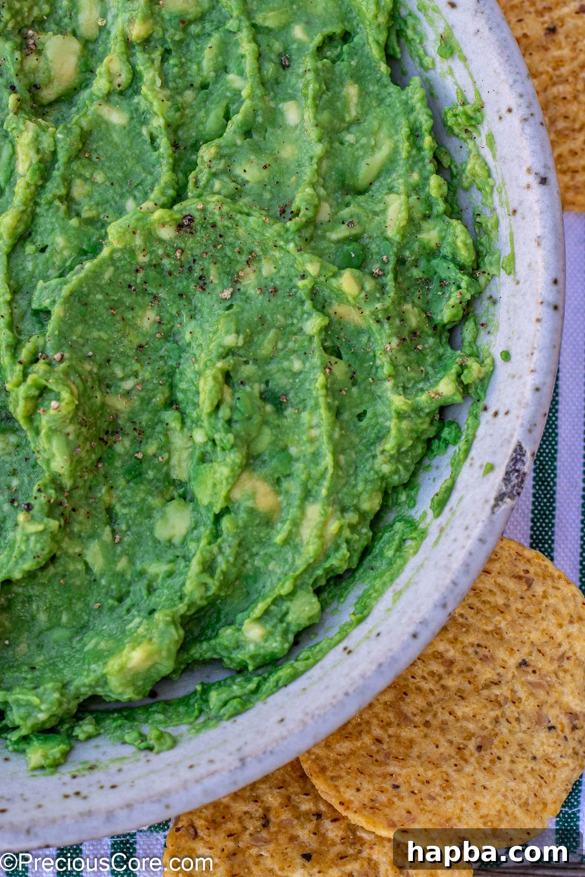 Effortless 4 Ingredient Guacamole 3 Close-up of a bowl of easy 4-ingredient guacamole served with a generous amount of crunchy tortilla chips.