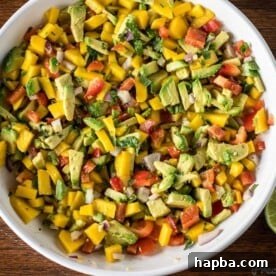 Mango Avocado Salsa in a white bowl, a vibrant and fresh appetizer.