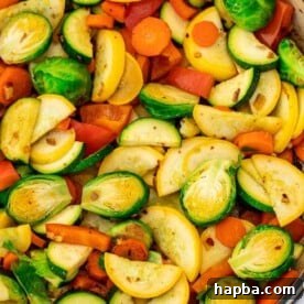 Sautéed vegetables in a braiser, featuring colorful Brussels sprouts, carrots, and squash.