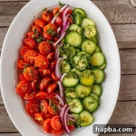 Tomato cucumber onion salad on a platter, bursting with freshness.