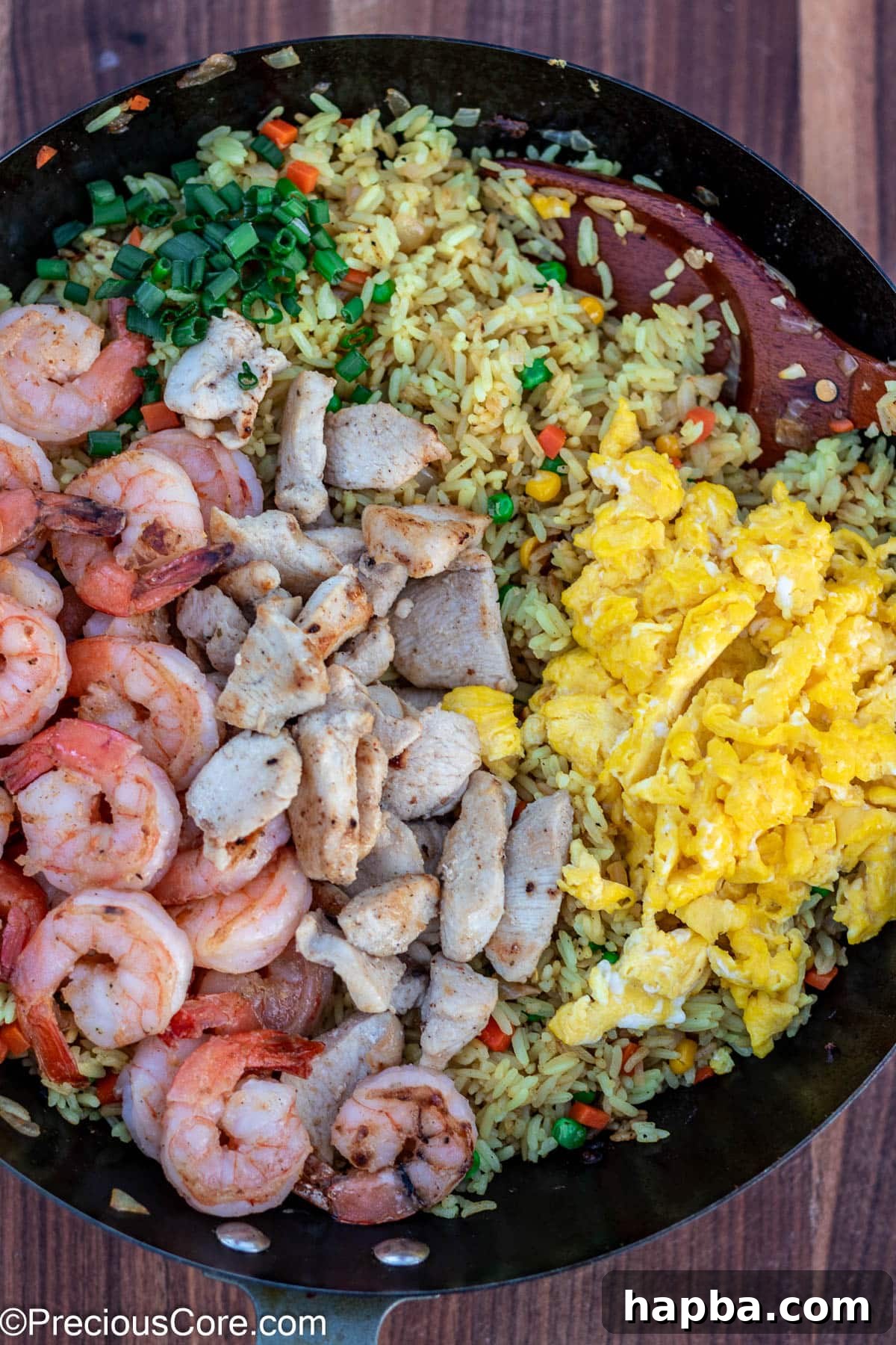 The finished fried rice, generously topped with an appealing mix of shrimp and chicken, ready to be served.