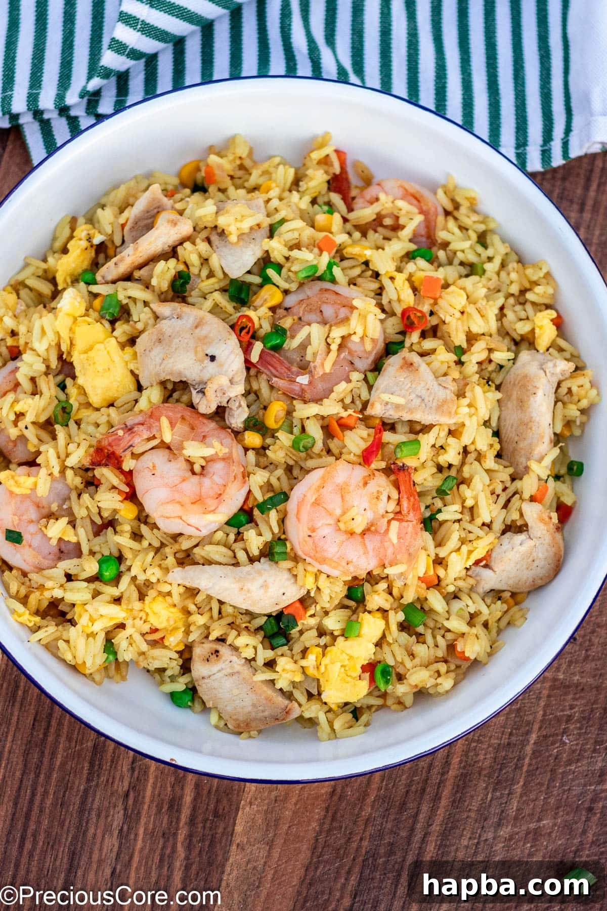 A beautifully plated portion of fried rice, generously topped with perfectly cooked chicken and shrimp, inviting you to dig in.
