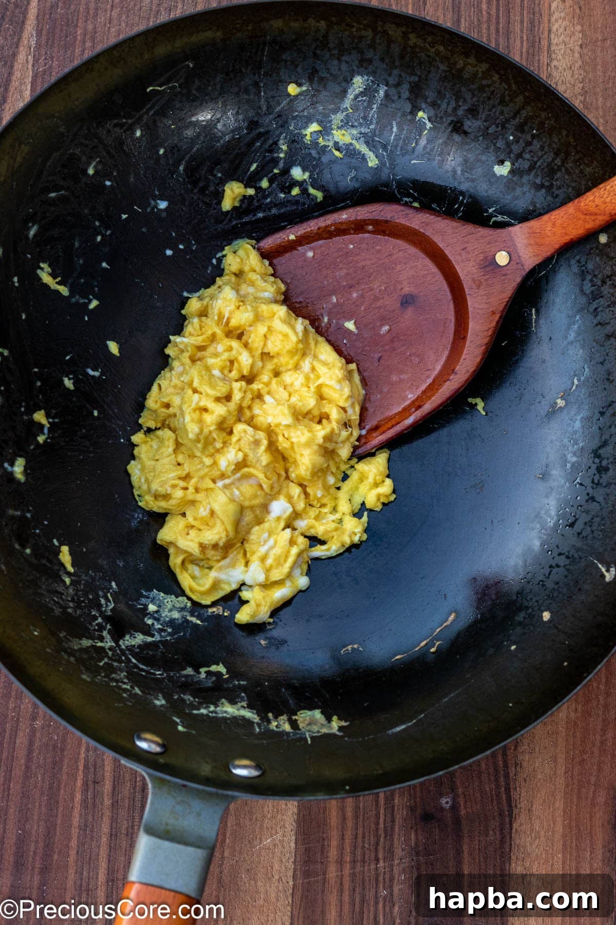 Perfectly scrambled eggs, light and fluffy, cooked in a wok, ready to be added to the fried rice.