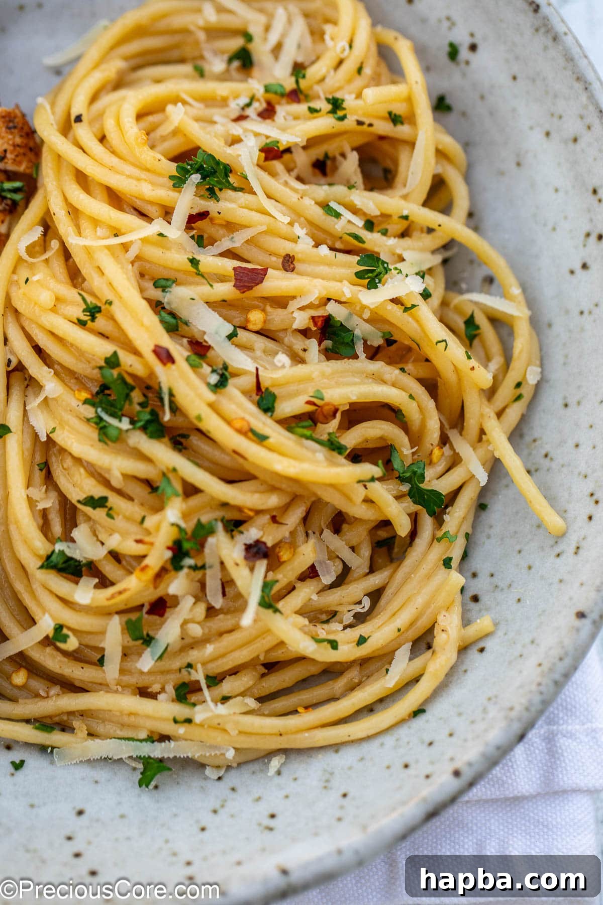 Close-up of a generous portion of garlic butter pasta in a white pasta bowl, ready to be served.