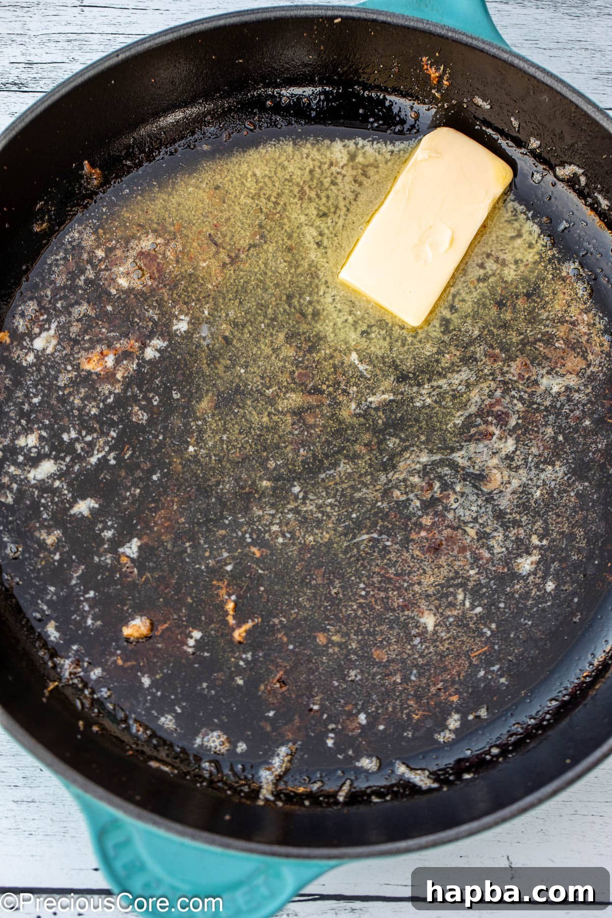Butter melting and bubbling in a cast iron skillet over medium heat.