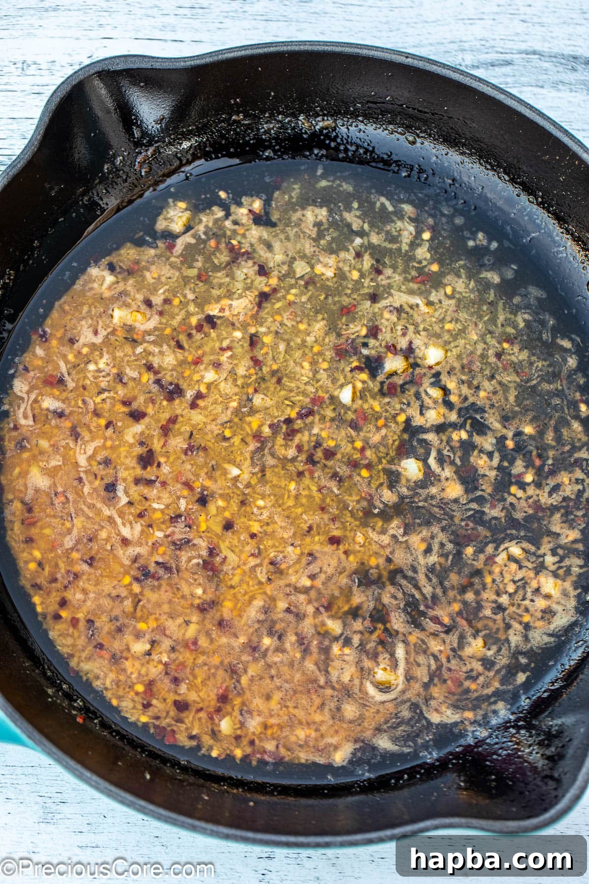 Minced garlic and melted butter simmering together in a cast iron skillet.