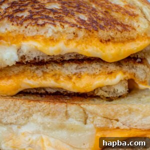 A stack of golden sourdough grilled cheese sandwiches cut in half.