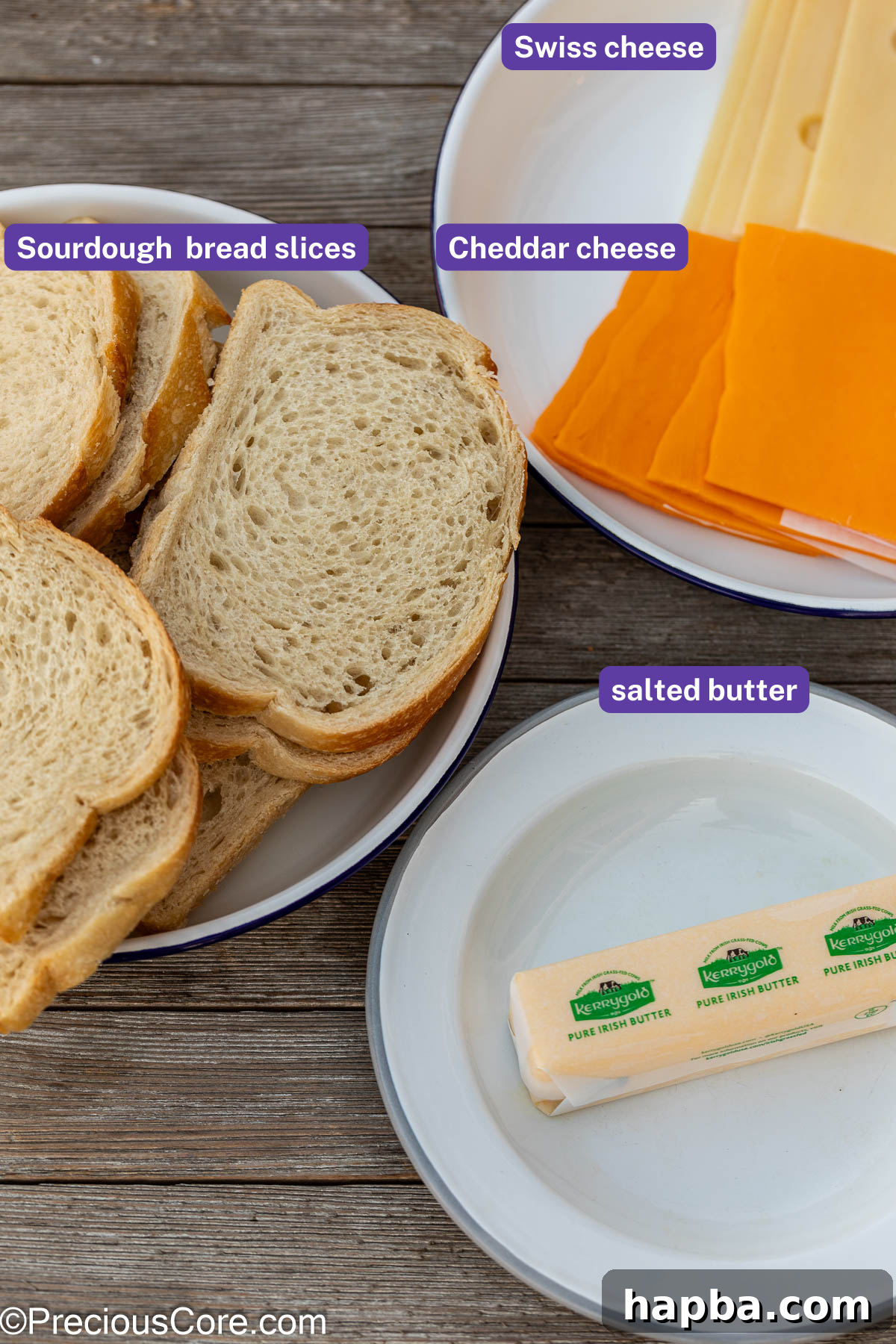 Fresh sourdough bread, a stick of butter, and cheese slices arranged for making grilled cheese.