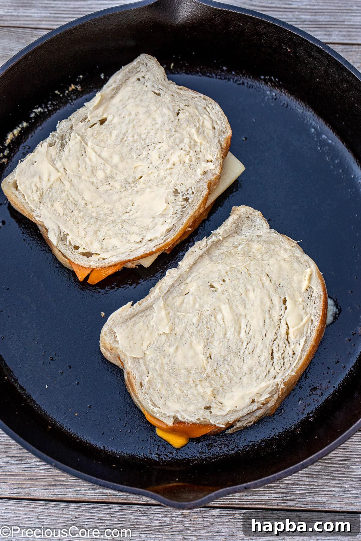 A sourdough grilled cheese cooking to golden perfection in a black cast iron skillet.