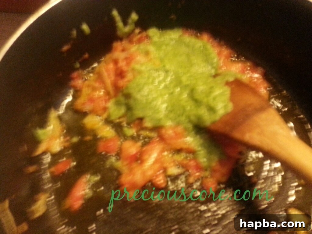 The aromatic paste and seasoning being stirred into the sauce.