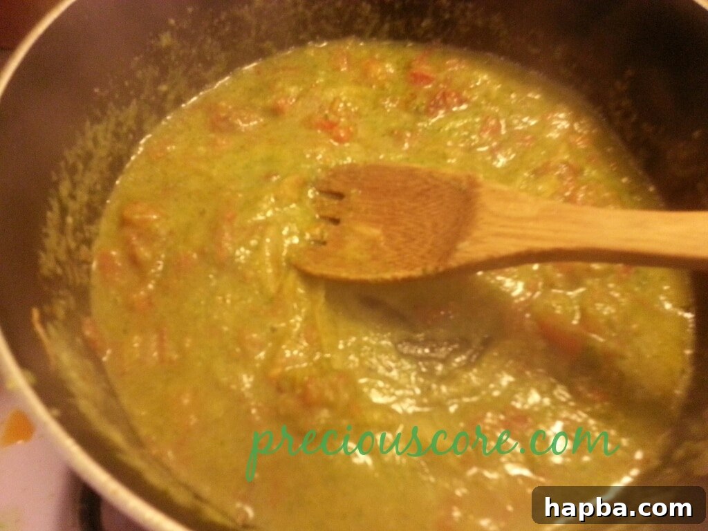 Cooked shrimp being added to the simmering sauce.