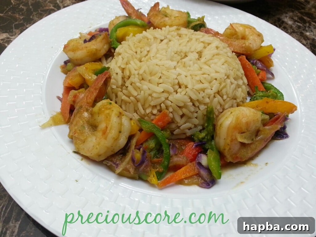 A serving of shrimp and vegetable stir-fry with brown rice in a bowl.