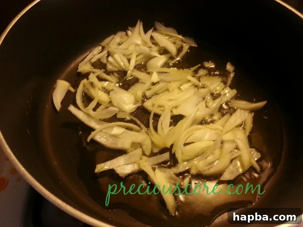 Chopped onions sizzling in olive oil in a pan.