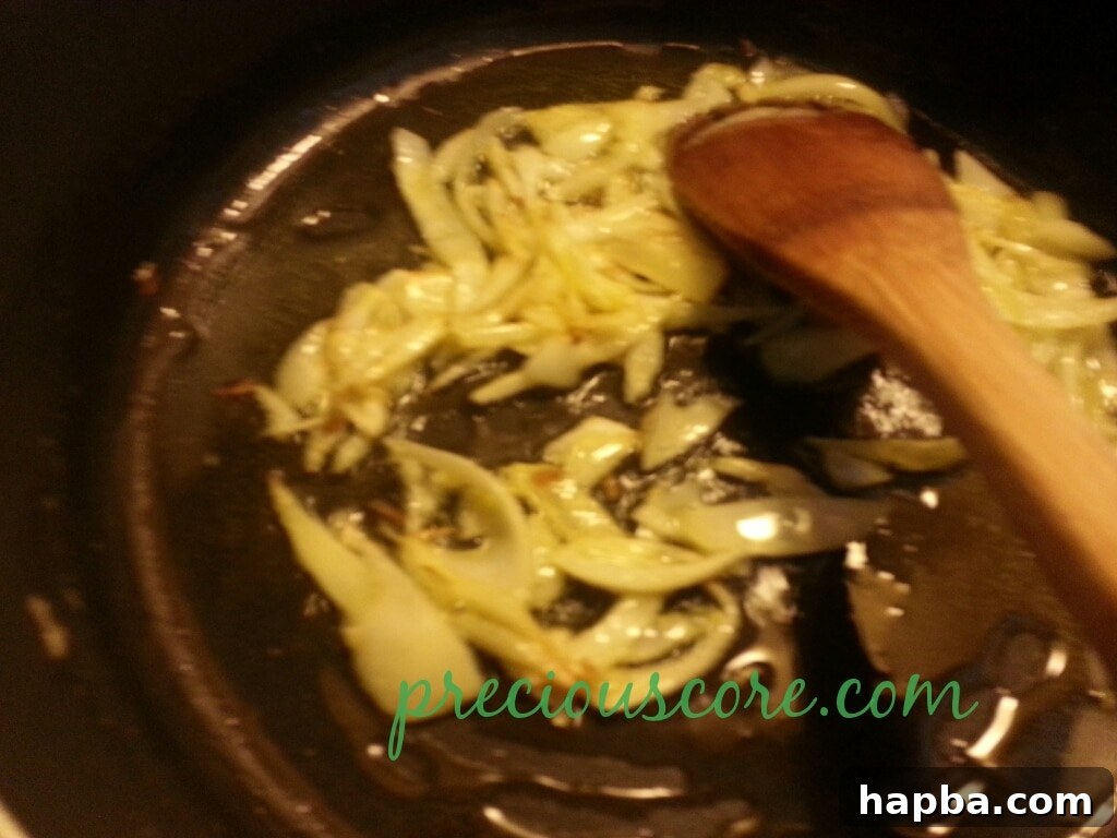Chopped tomatoes added to the pan with sautéed onions.