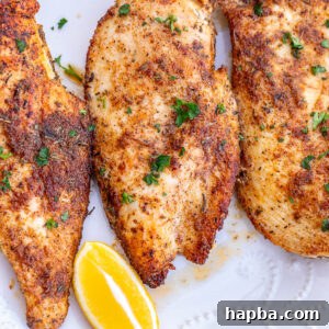 Thin sliced chicken breasts served with lemon wedges.