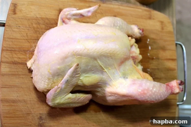Whole chicken on a wooden cutting board.