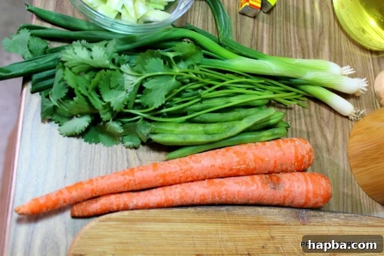 Carrots, green beans, and other produce on a wooden cutting board.