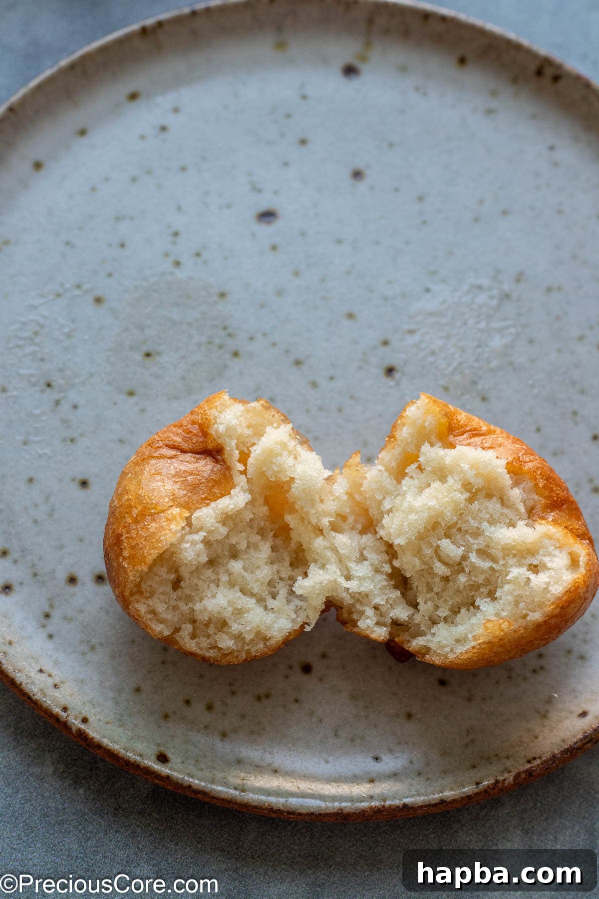 A Puff Puff cut in half, showcasing its perfectly airy and soft interior texture.