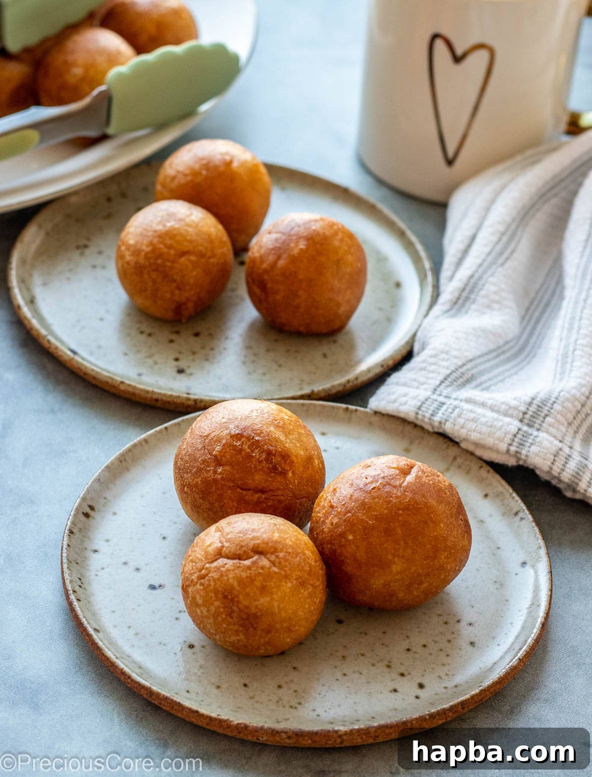 Two small plates featuring African snacks, including fluffy Puff Puff and another fried delicacy.