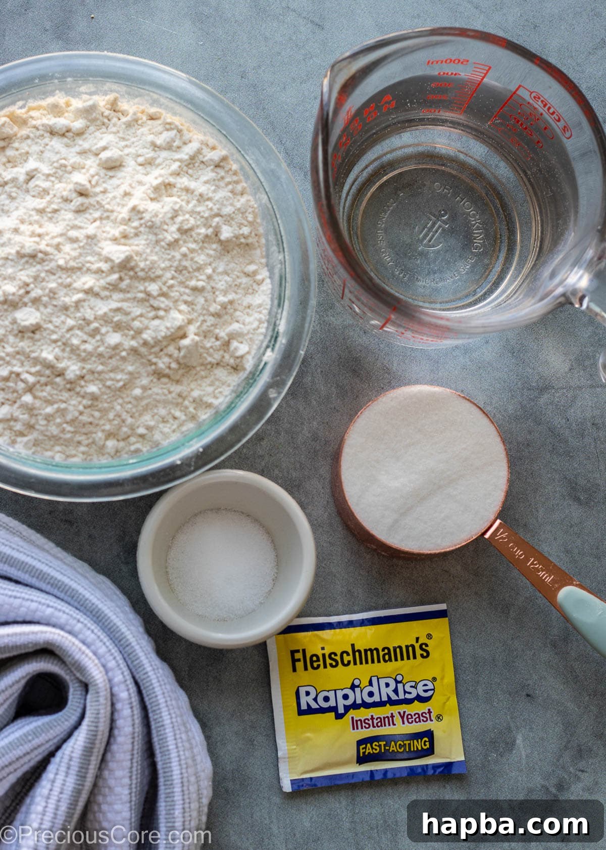 Individual ingredients for Puff Puff displayed on a wooden board: flour, sugar, yeast, and salt.