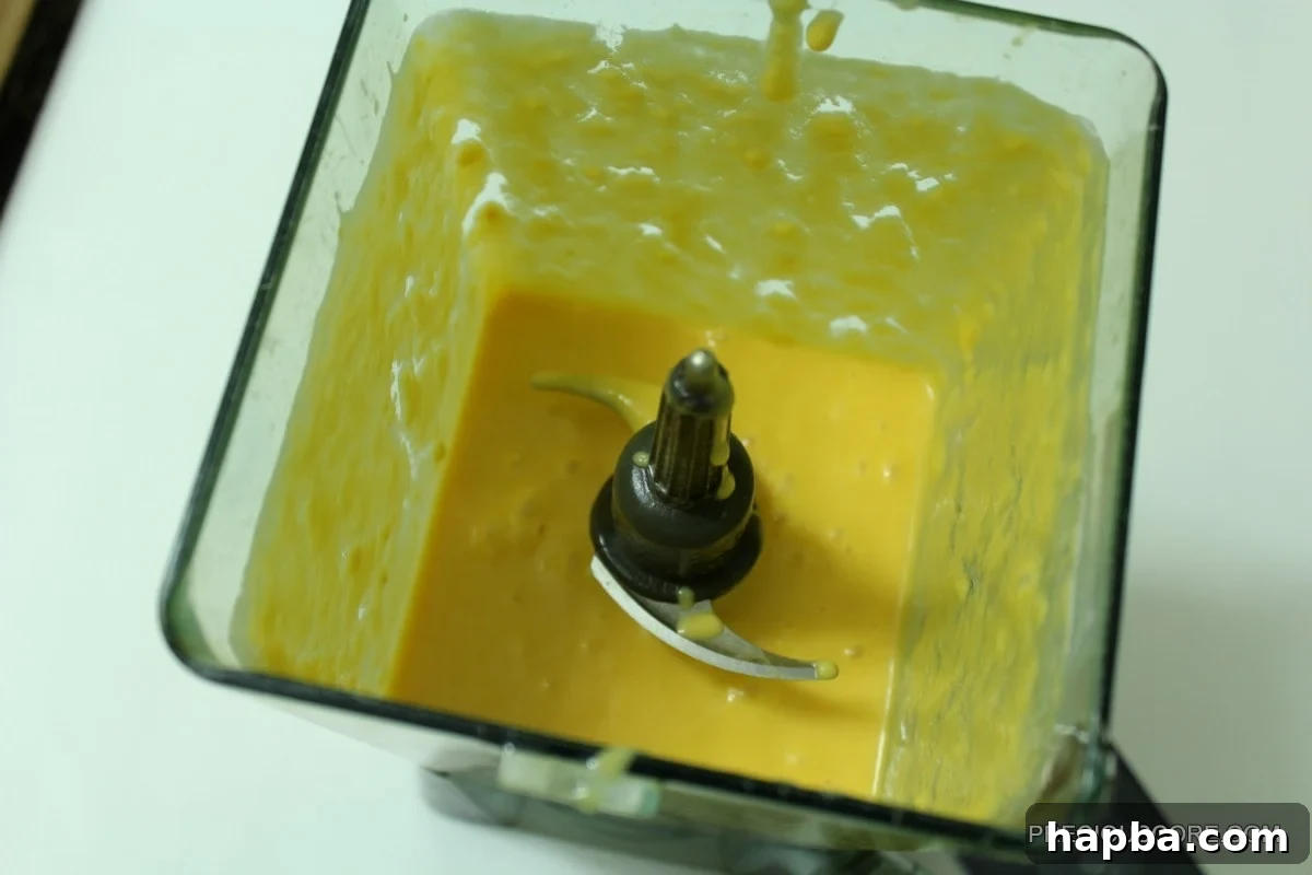 Close-up of the smooth, blended mango and coconut mixture in a blender