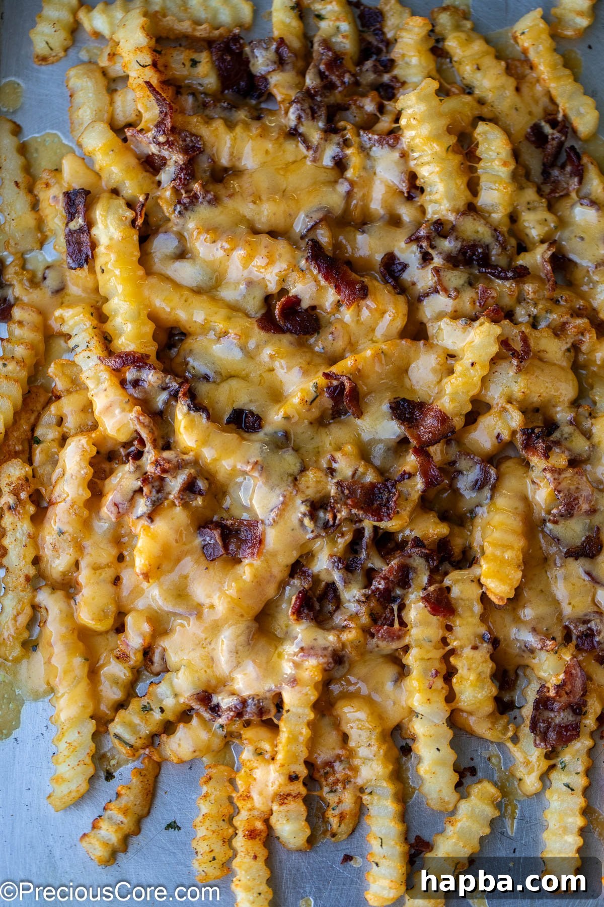 Fries completely covered with bubbling, melted cheese and crispy bacon bits.