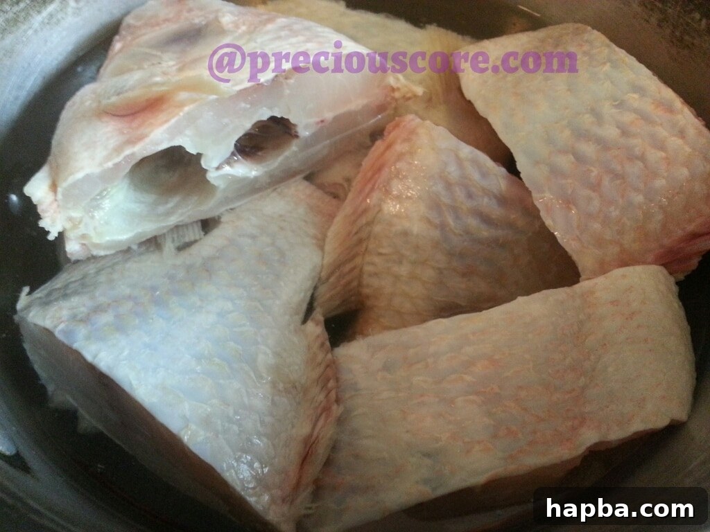 Fish seasoned in a pot, ready for cooking.