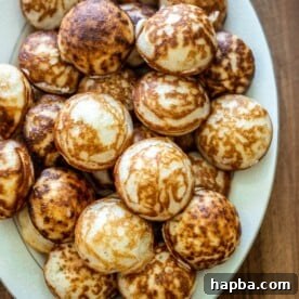 A white tray filled with freshly made Vitumbua, highlighting their attractive shape and inviting texture.