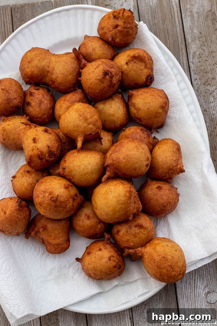 A platter lined with paper towels, generously filled with golden-brown banana fritters, showcasing their inviting texture.