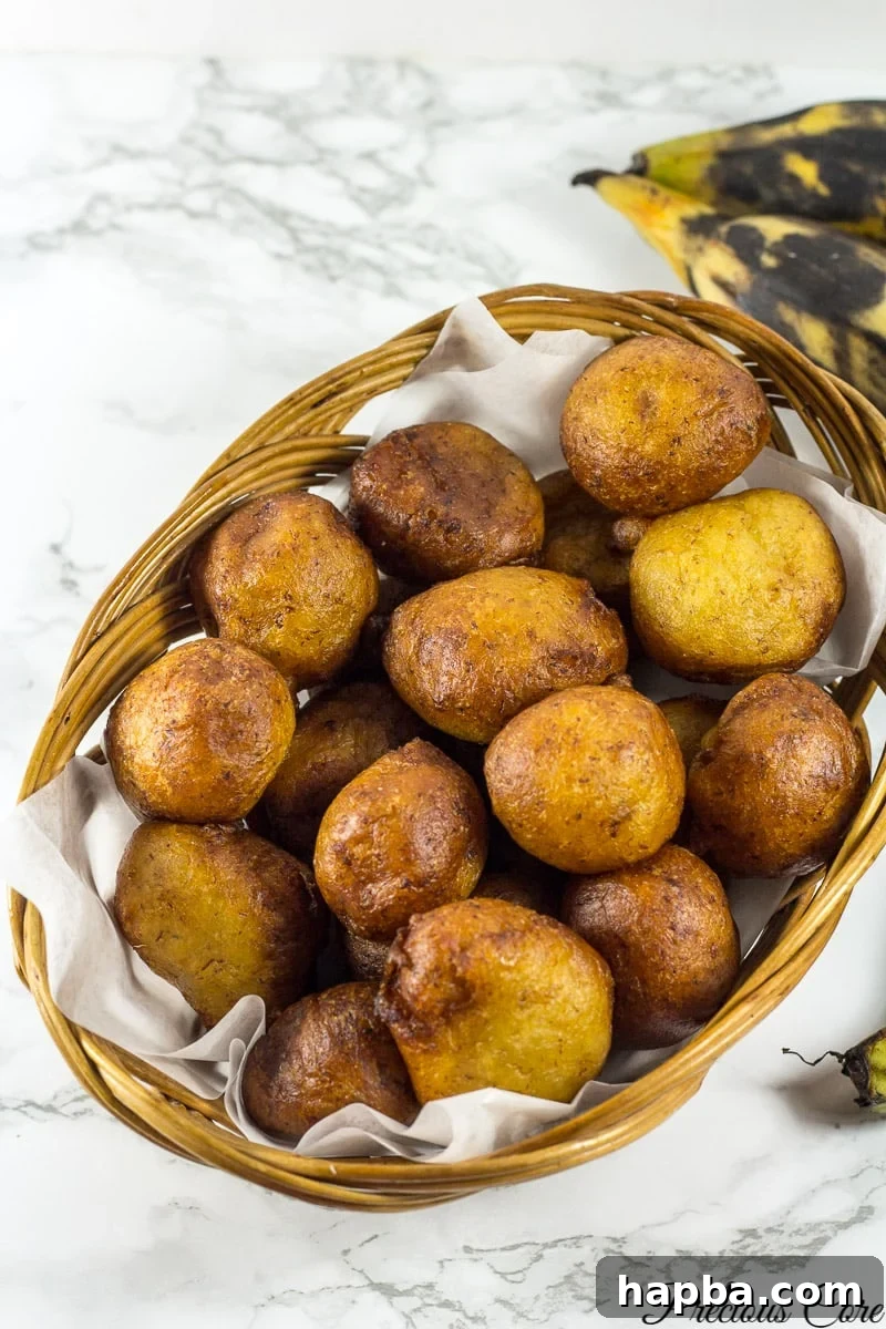 A rustic woven basket overflowing with golden-brown Plantain Puff Puff, inviting you to enjoy this sweet African delicacy.