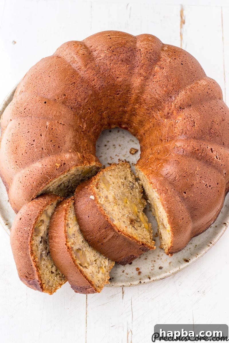 A slice of elegant plantain bundt cake resting on a plate, highlighting its moist texture and inviting golden hue.