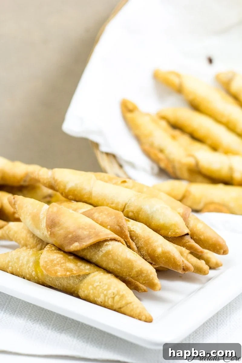 A charming arrangement of Cameroonian fish rolls, presented on a white plate and in a rustic basket, showcasing their golden-brown and inviting appearance.