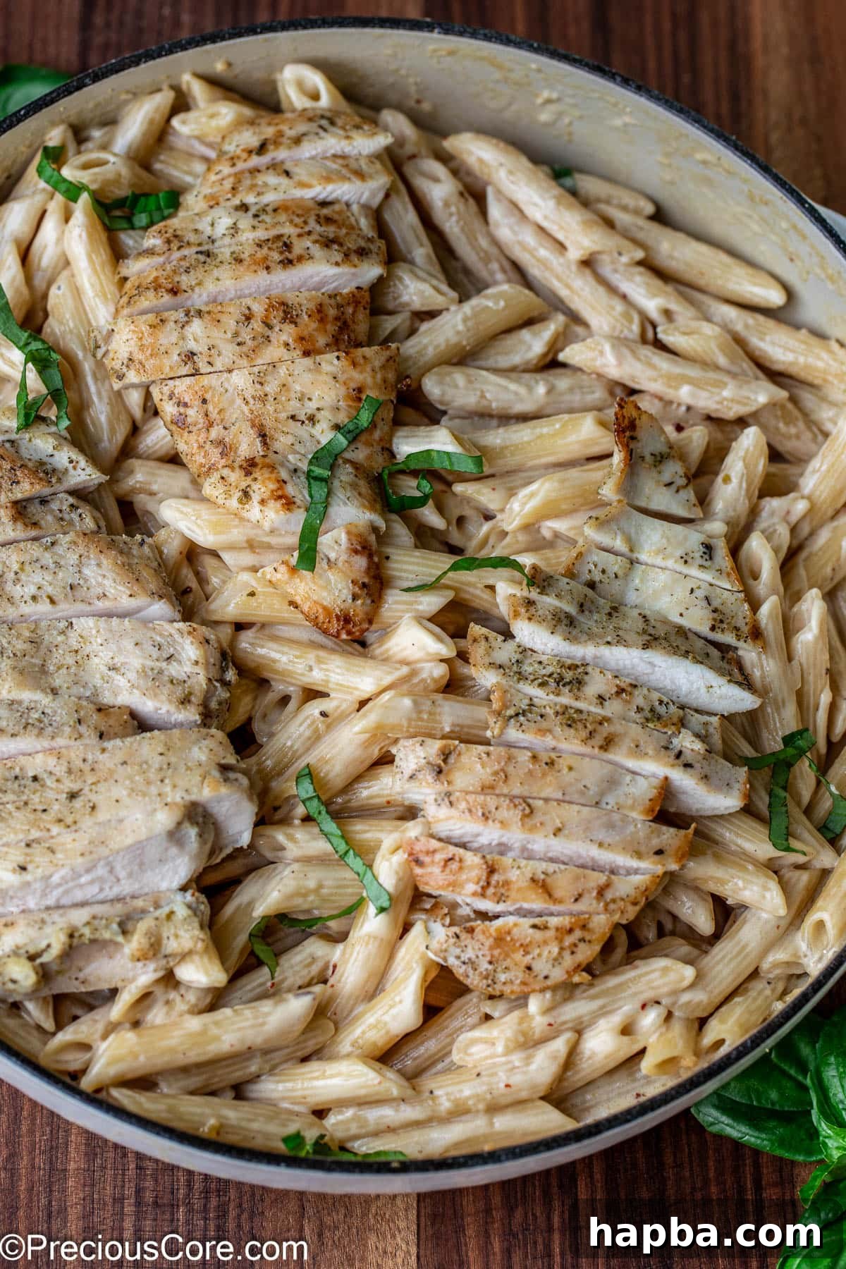 Creamy garlic parmesan pasta generously topped with sliced chicken breast and fresh herbs.