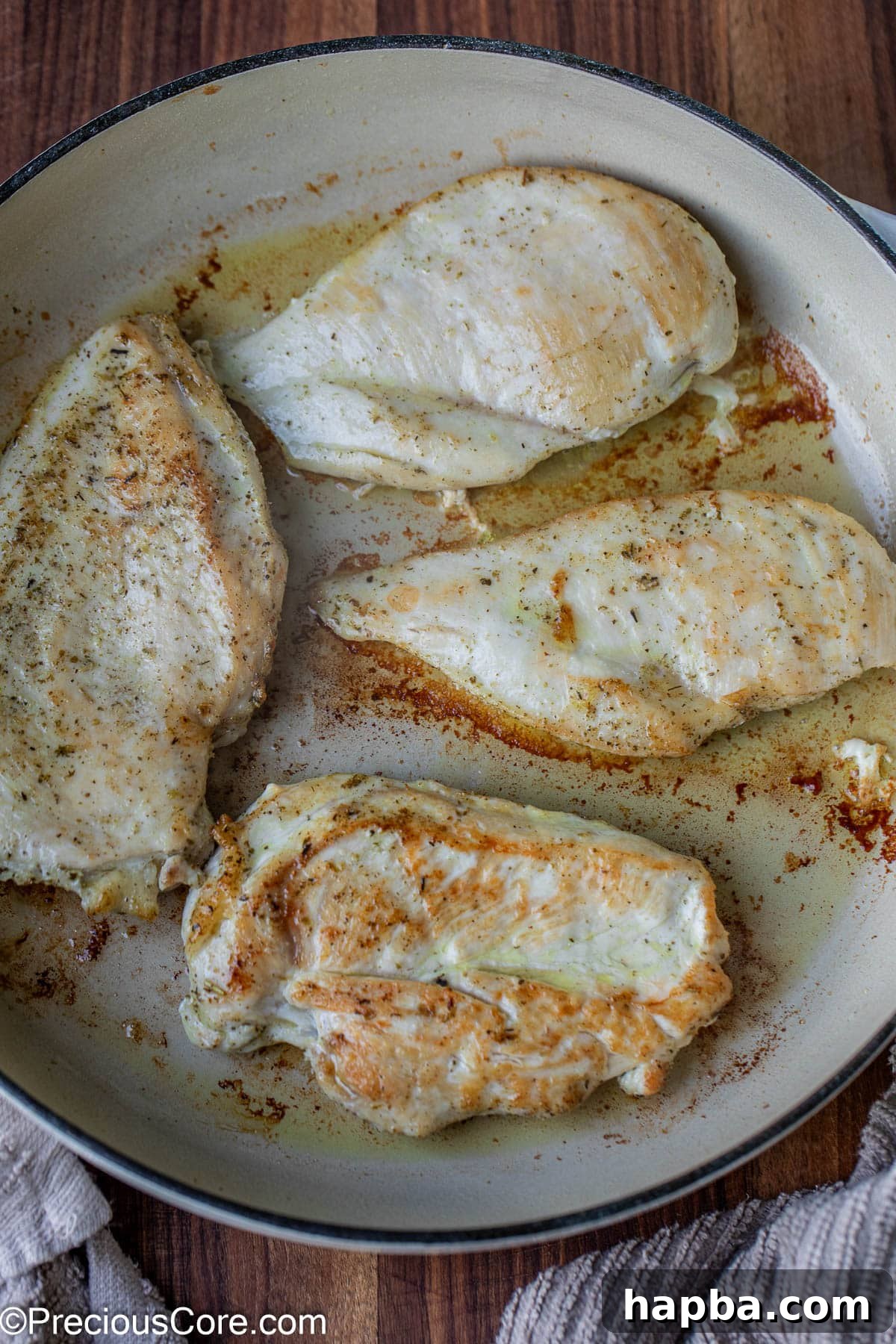 Perfectly cooked, golden-brown chicken breasts resting in a robust cast iron skillet.