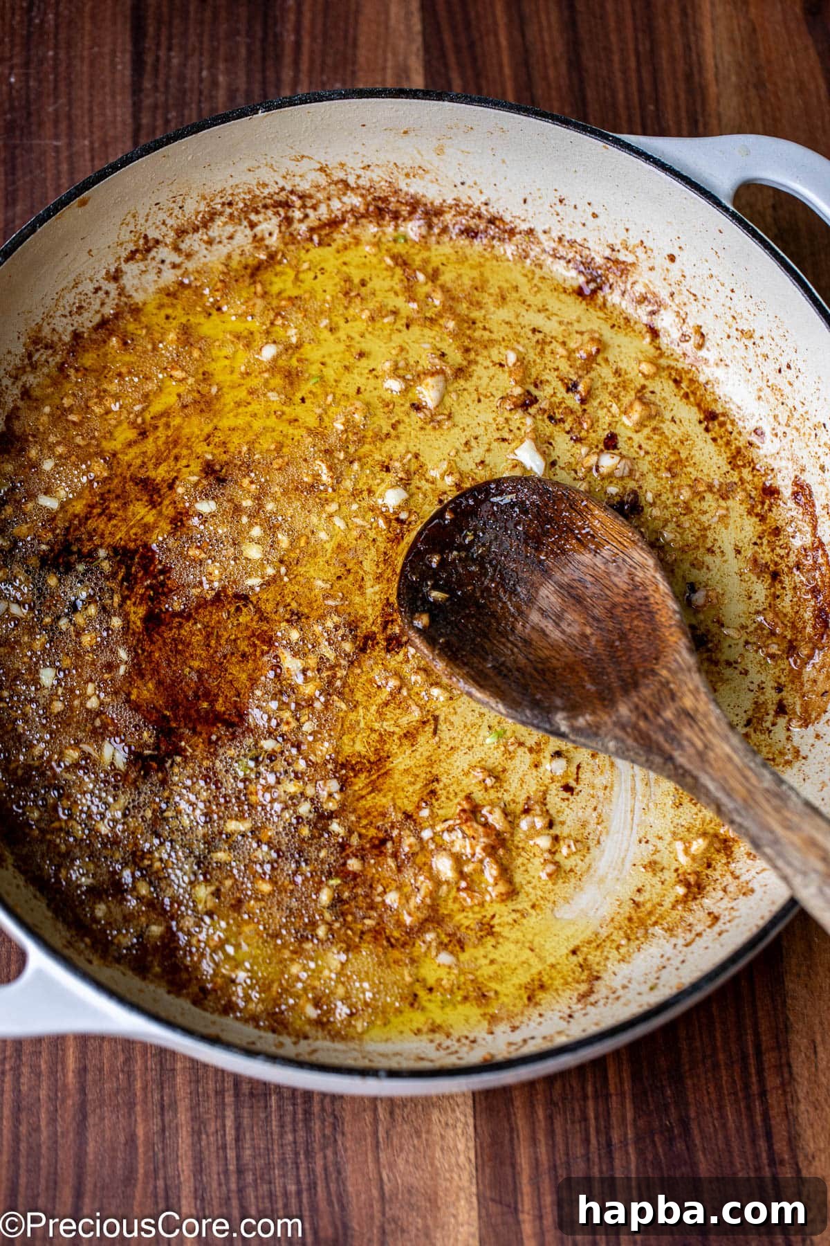 Finely minced garlic cloves gently sautéing in rich melted butter within a skillet, releasing a fragrant aroma.