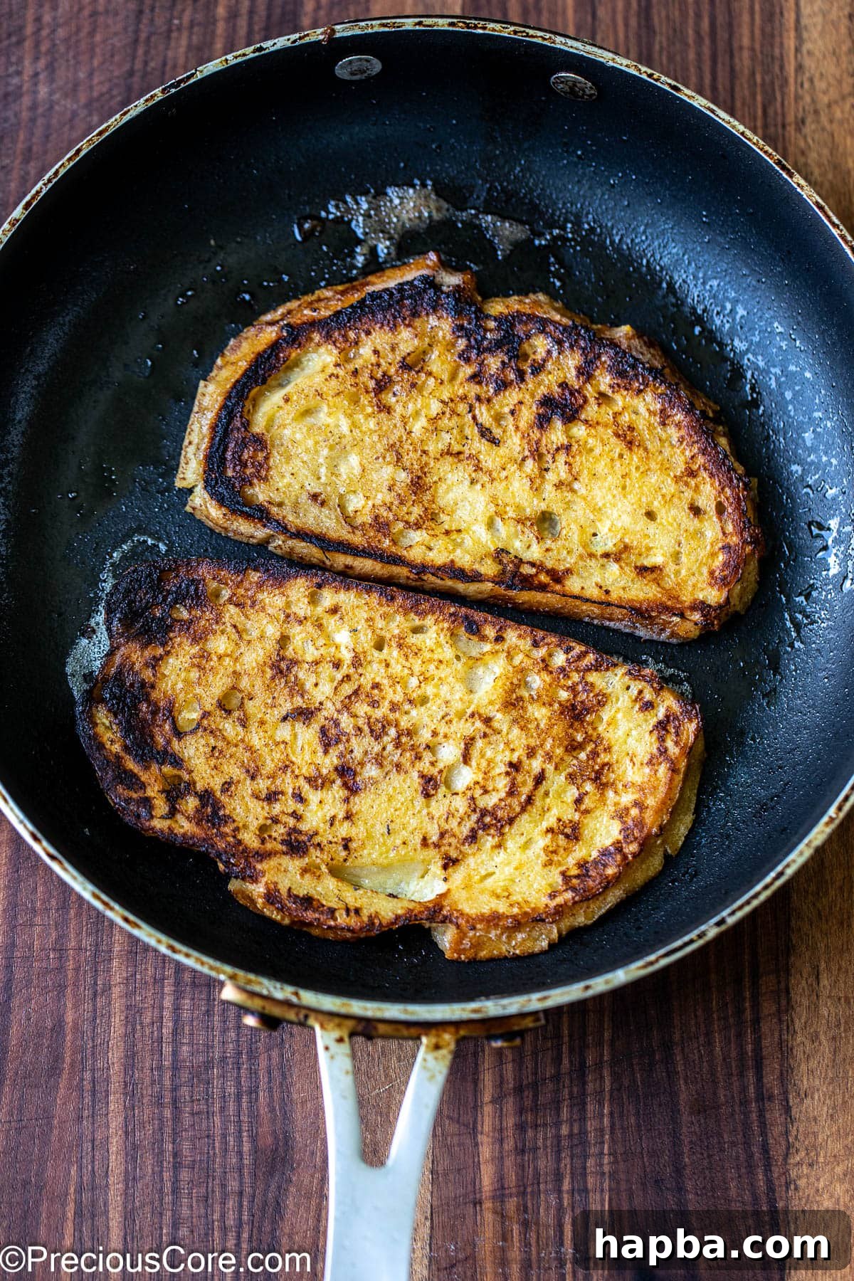 2 bread slices cooking in a skillet.