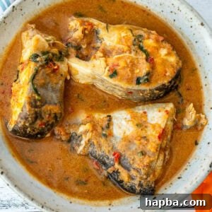 A bowl with three steaks of catfish in pepper soup, invitingly presented.