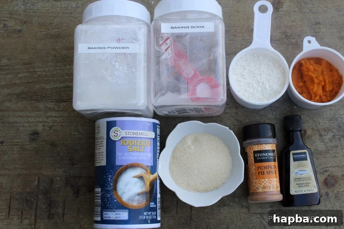 Autumn Spiced Pumpkin Roll 4 Cake ingredients including baking powder, salt, and pumpkin pie spice laid out on a surface.
