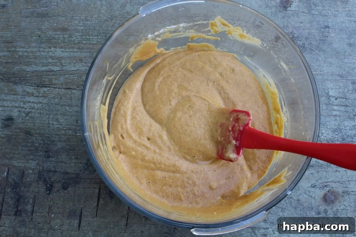 Autumn Spiced Pumpkin Roll 10 Bowl filled with smooth, orange pumpkin roll cake batter.