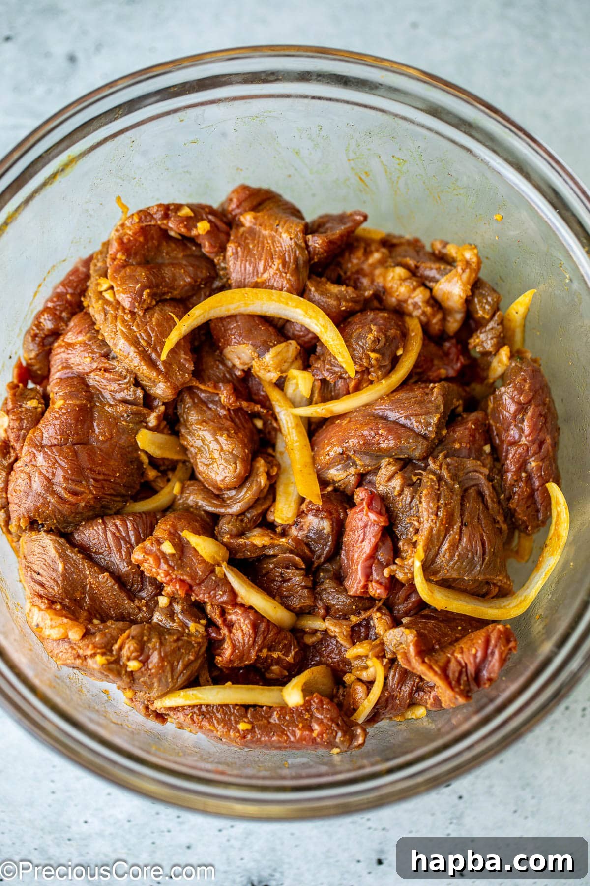 Restaurant-Style Beef Shawarma at Home 6 Beef strips being marinated in a bowl, thoroughly coated with spices.