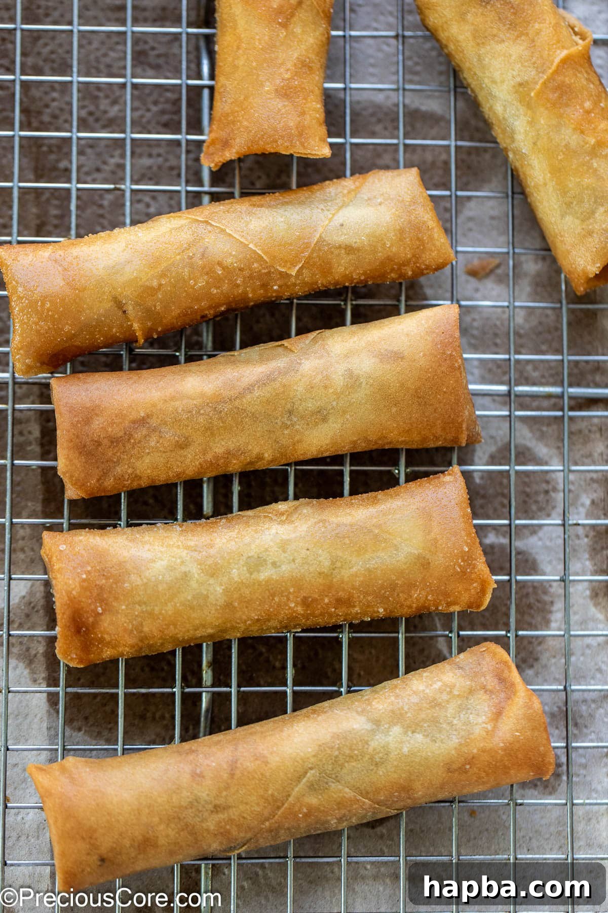 Deep fried rolls cooling on a rack.