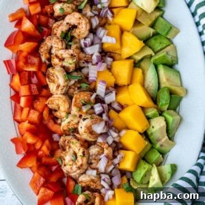 Diced mango, cooked shrimp, avocado, and bell peppers, presented as the final Mango Shrimp Salad.