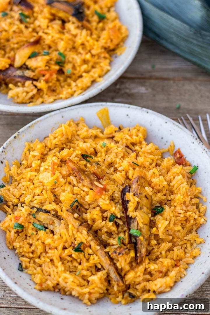 Palm oil jollof rice served in ceramic bowls, garnished with fresh herbs.