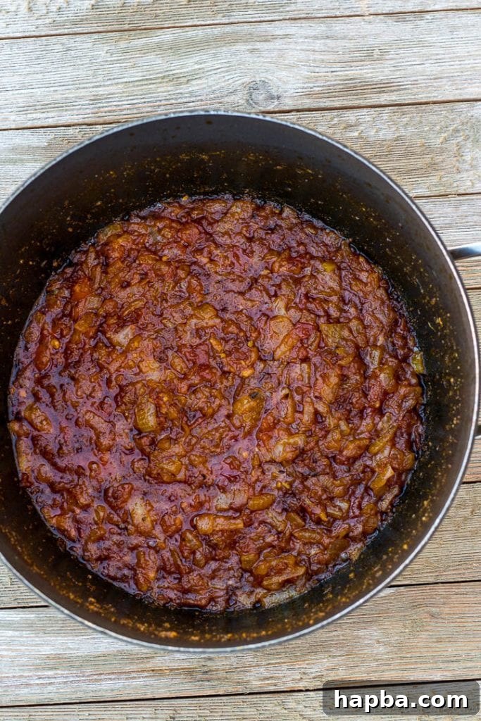 Rich tomato and palm oil sauce simmering in a pot, forming the base for palm oil jollof rice.